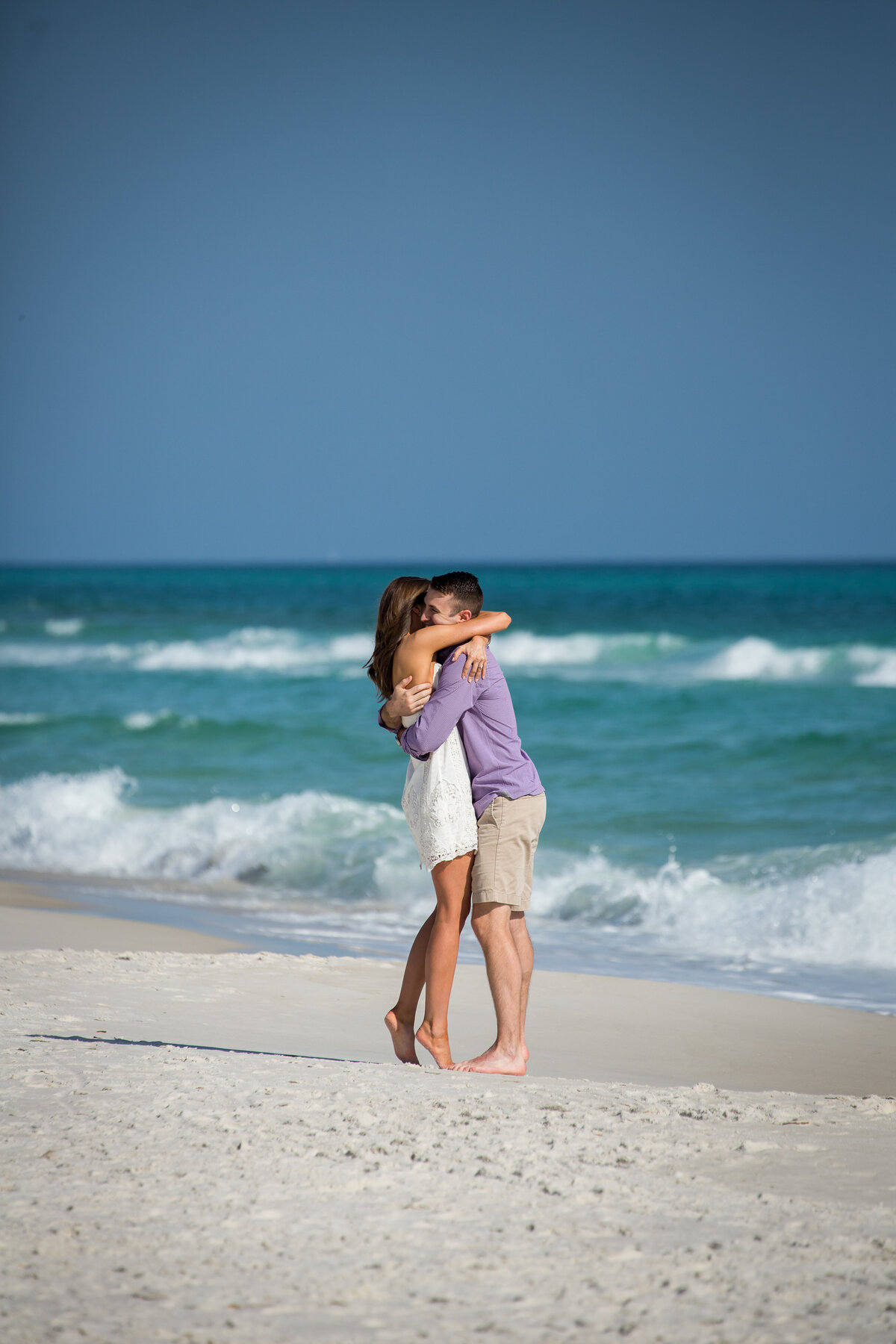 newly engaged couple hugging in front of Gulf at Rosemary Beach, FLorida.