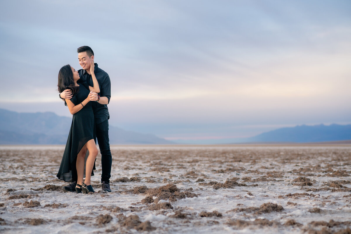 Death Valley elopement bride and groom at Badwater Basin during sunset embracing.