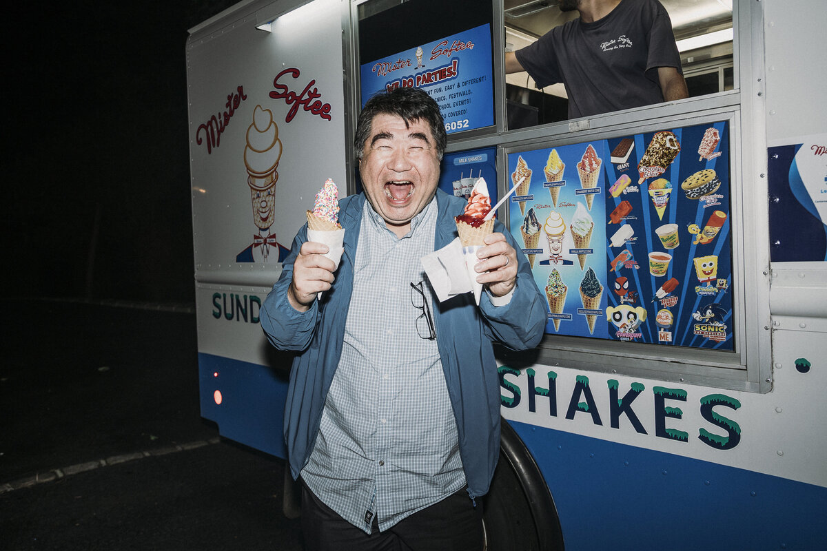 Photo of smiling guest with Mister Softee ice cream in private backyard party by Mira Park Photography NY based wedding photographer