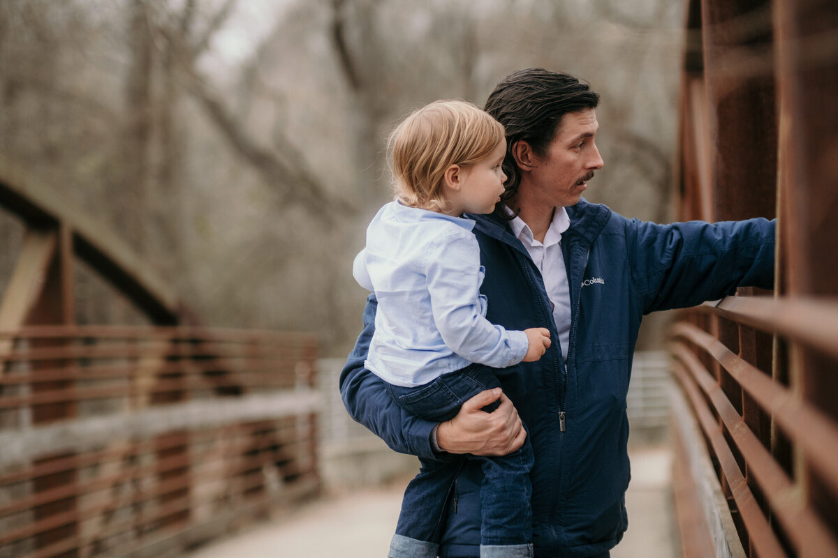 Dad holds his son showing him something.