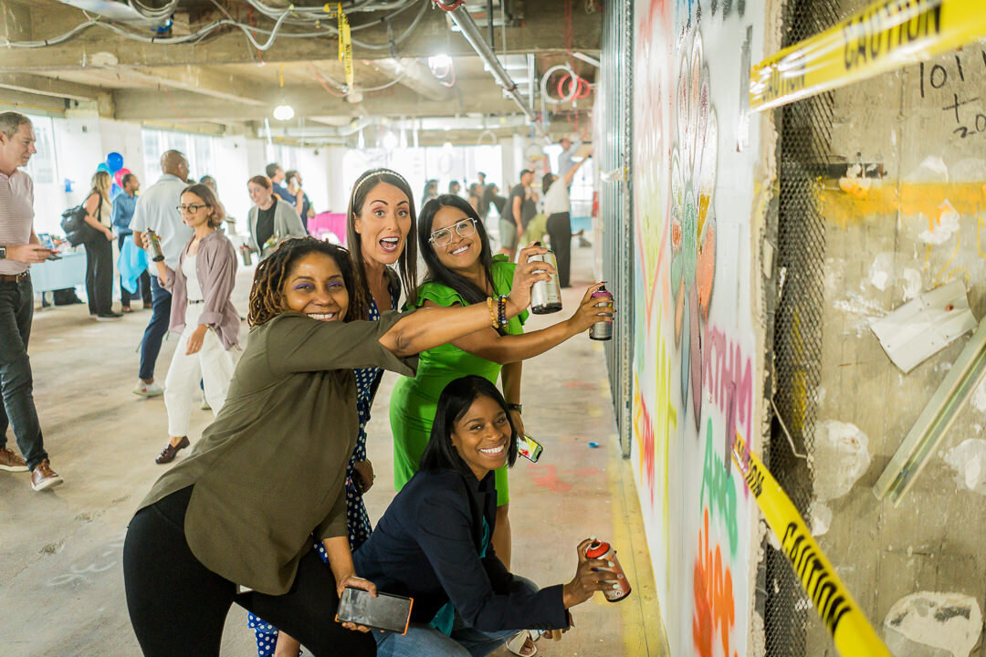 Corporate event photography of group painting mural together at business team building event new jersey.