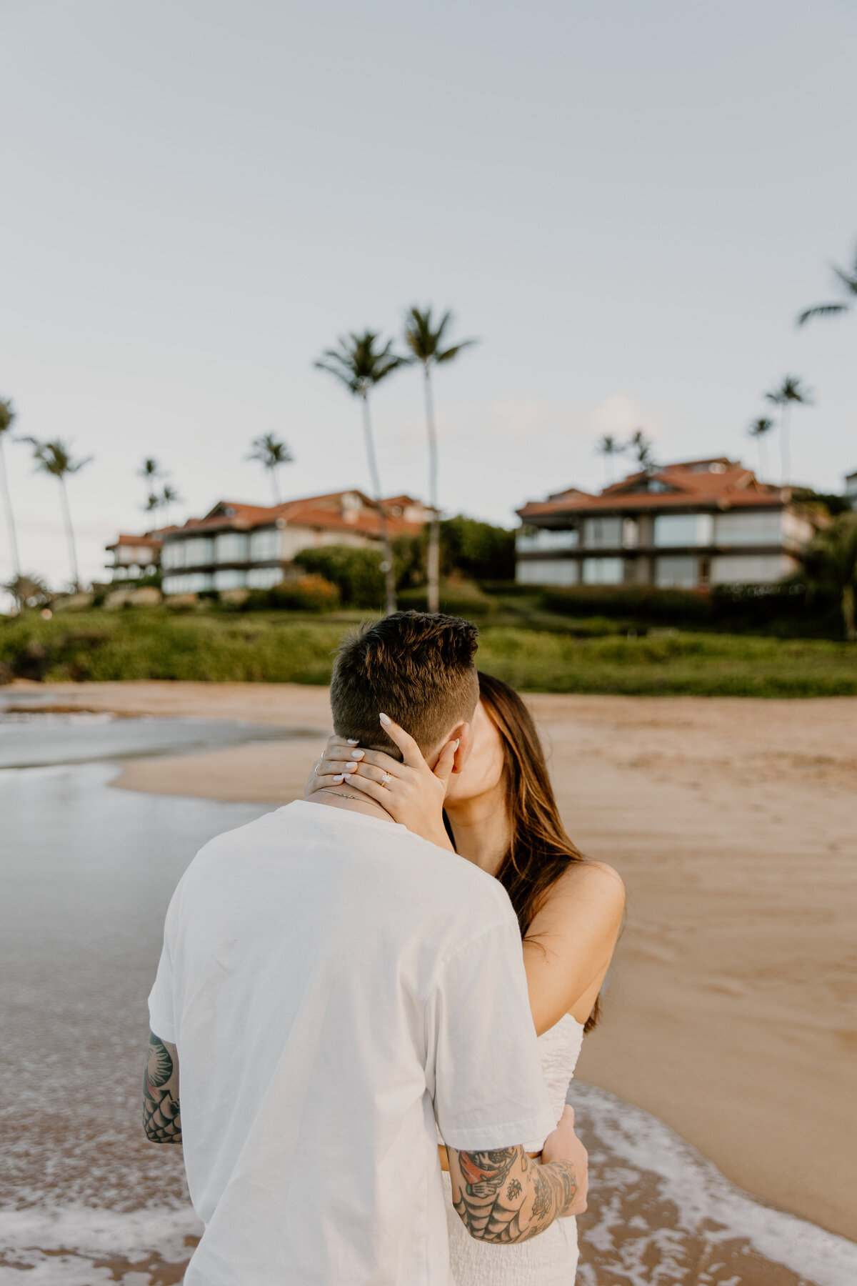 Hawaii Engagement Photographer captures woman kissing fiance during beach engagements