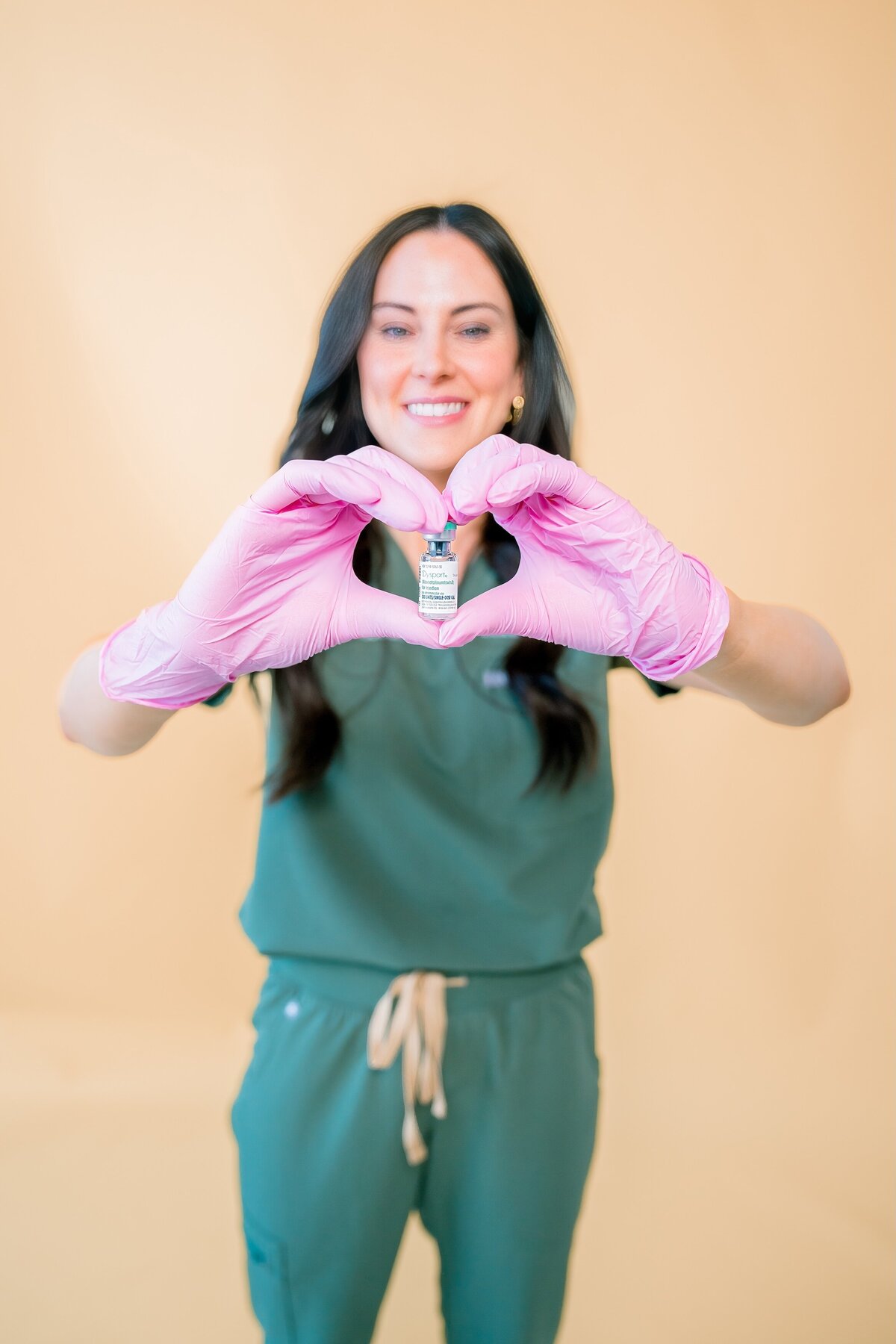 Branding photo in studio at Derma Percision. Nurse Injector holding small bottle of botox