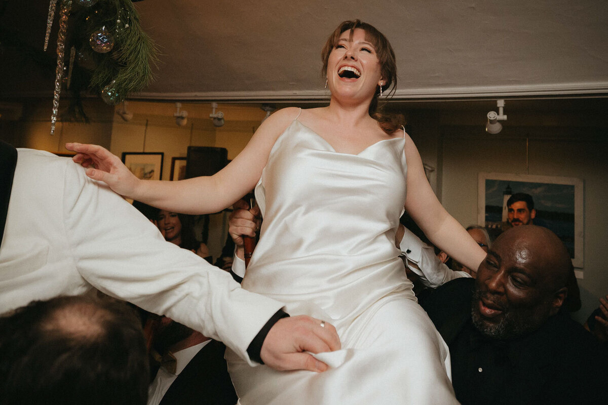 Bride lifted by friends at a wedding reception