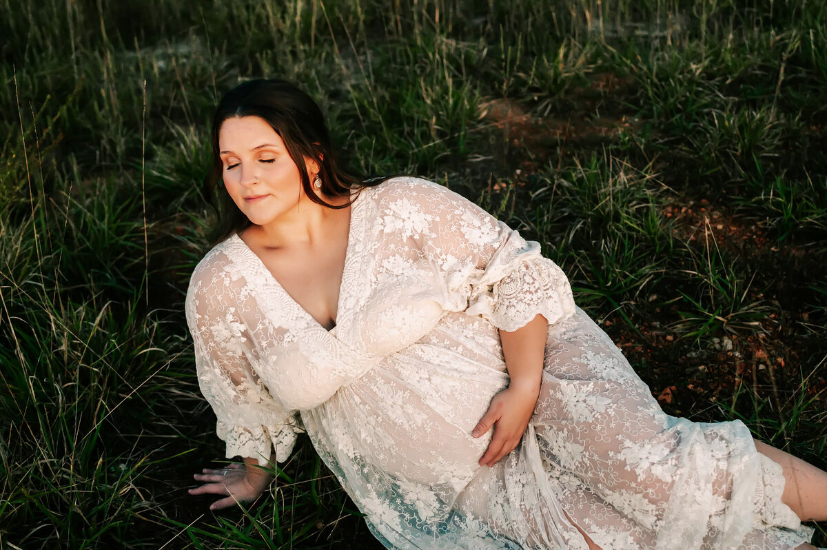 maternity photo of mom holding bump closing eyes during Joplin MO maternity photography session