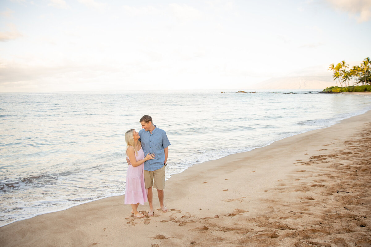 Maui Family Photographers capture couple kissing at water during family beach photos