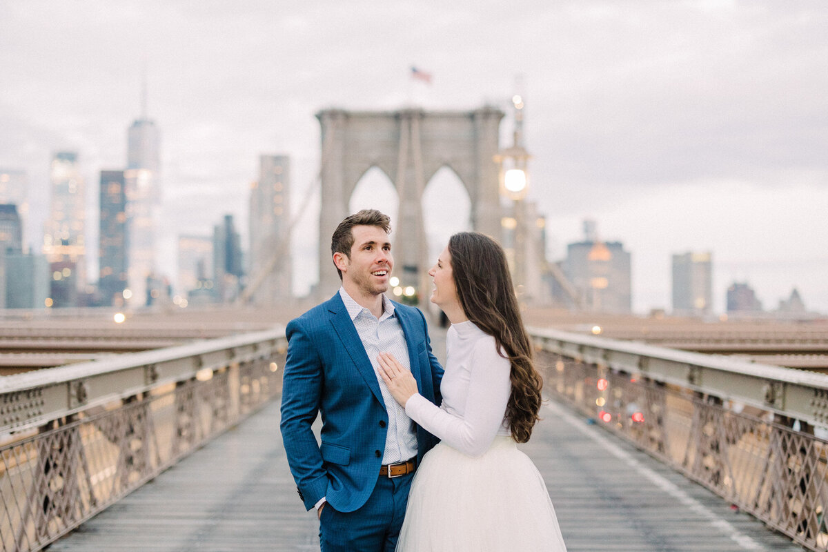 An engagement photo taken at sunrise on the Brooklyn Bridge in New York City
