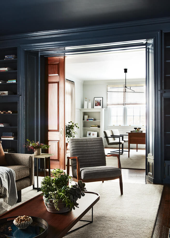 A historic home design features a navy blue family room and a light grey home office, blending rich color with timeless architectural details.