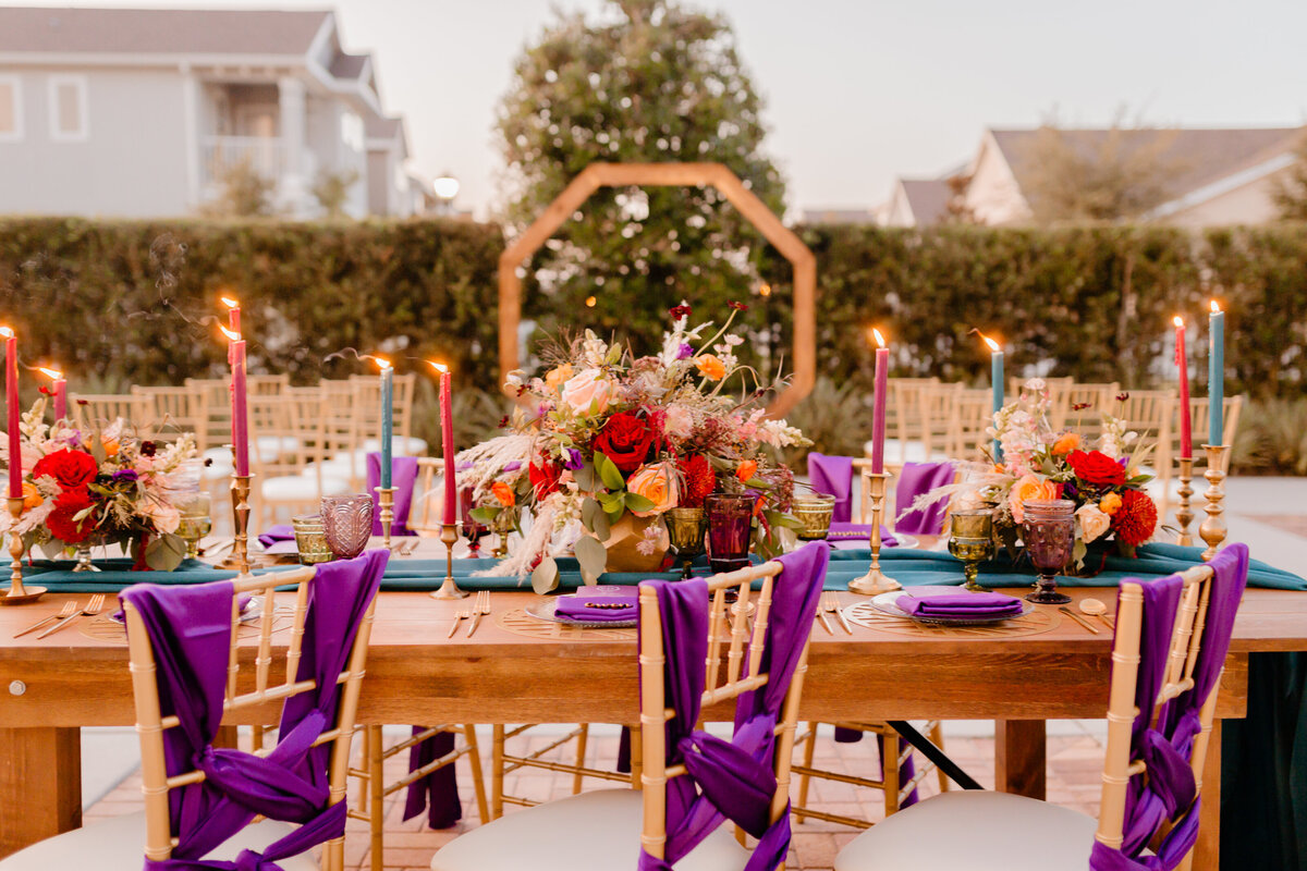 alt="tapered candles chairs and wedding reception"