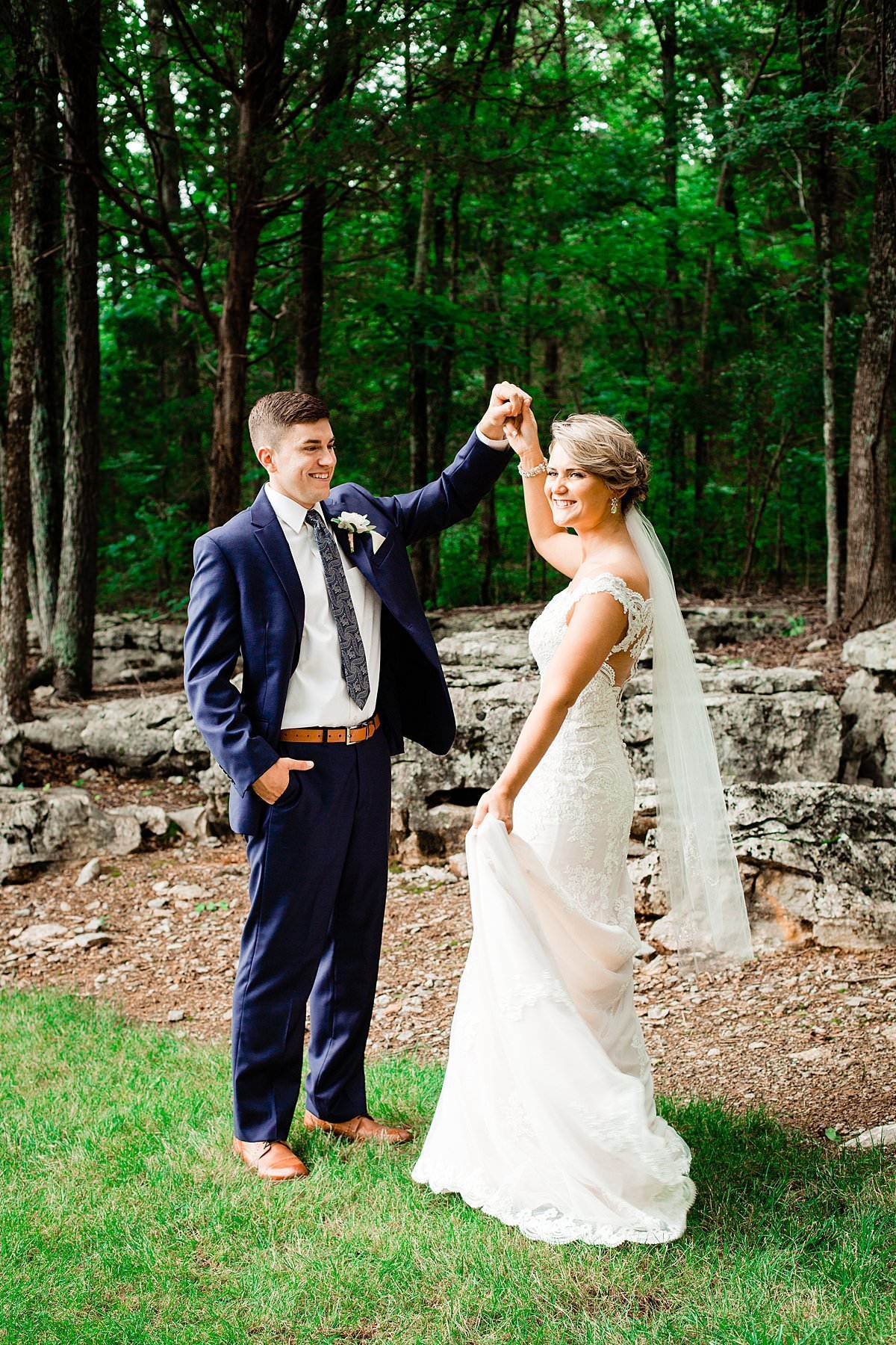 Bride smiling at camera over her shoulder while her fiance spins her