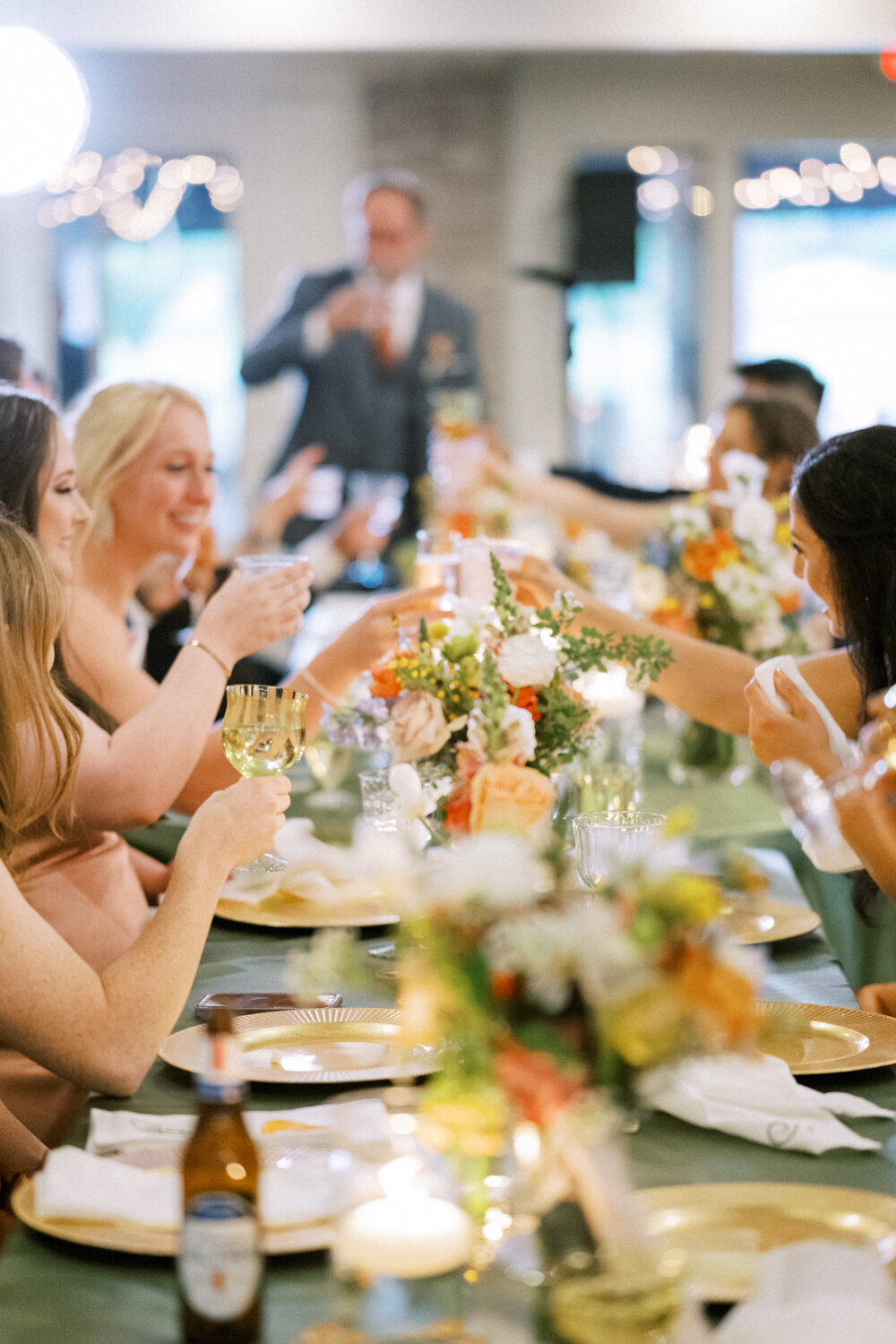 guests-cheering-with-colorful-glasses-over-colorful-flowers
