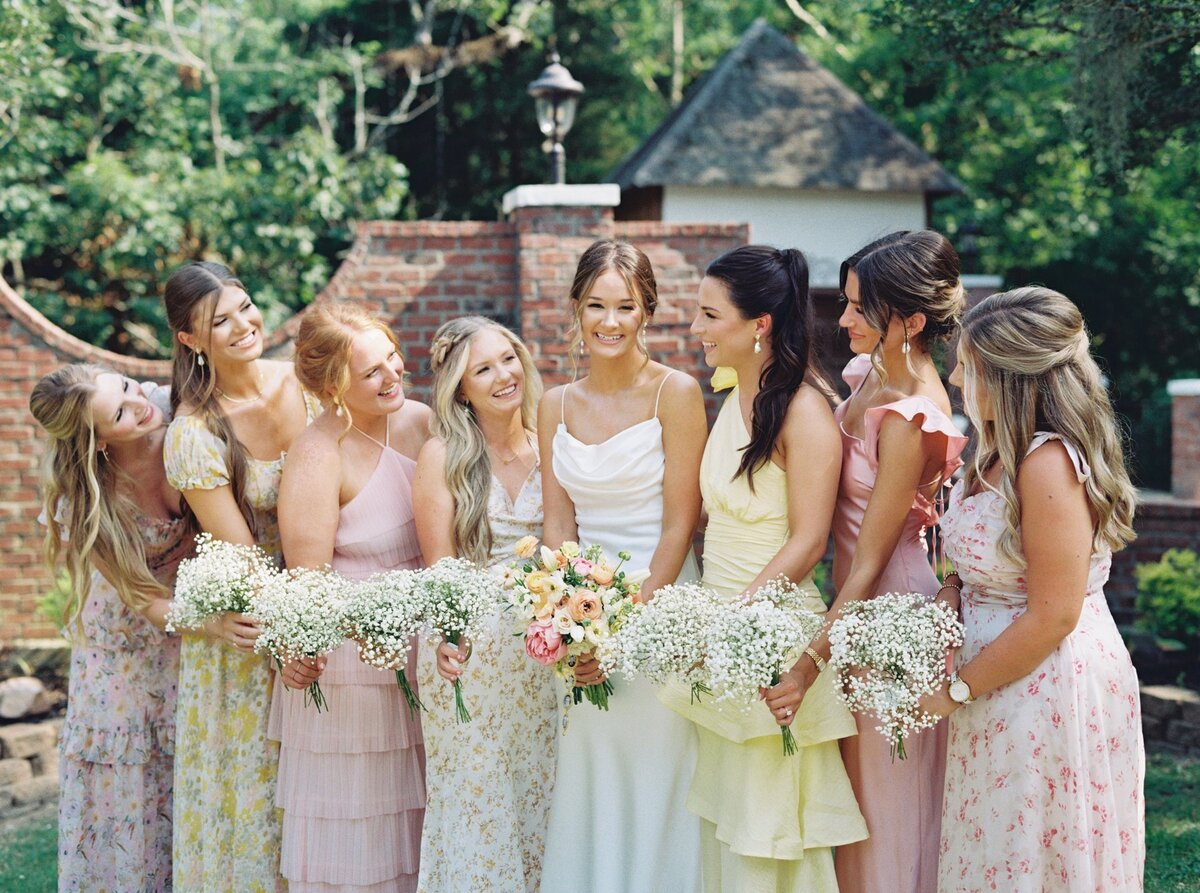 Bridesmaids in vibrant spring dresses holding colorful bouquets, captured on film by Morgan Alysse, Louisiana film photographer.