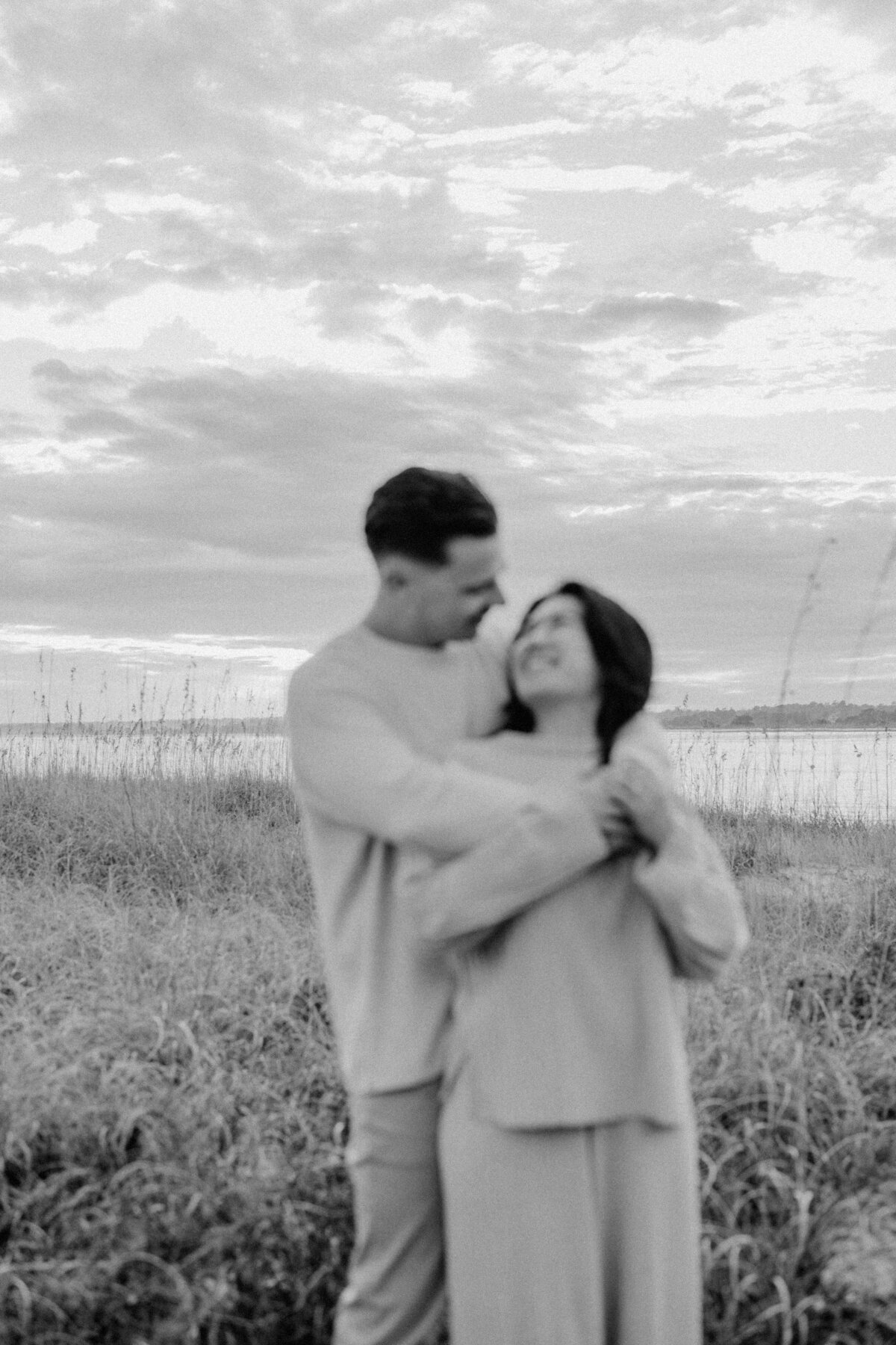 Engaged couple sharing a laugh in Wilmington Beach, natural light engagement photos