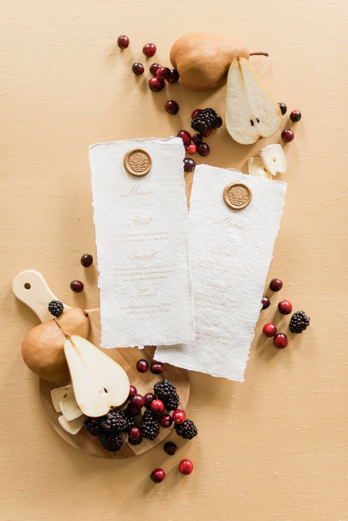 Romantic wedding stationery and details flatlay, styled by Wedding Stylist Rebekah Bronte, featuring vintage style wedding stationery and details, fruit, florals, and tones of honey, berry, green and brown. 