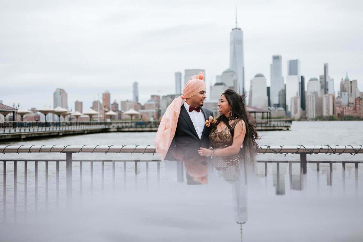 Couple stare at each other in front of New York City skyline.