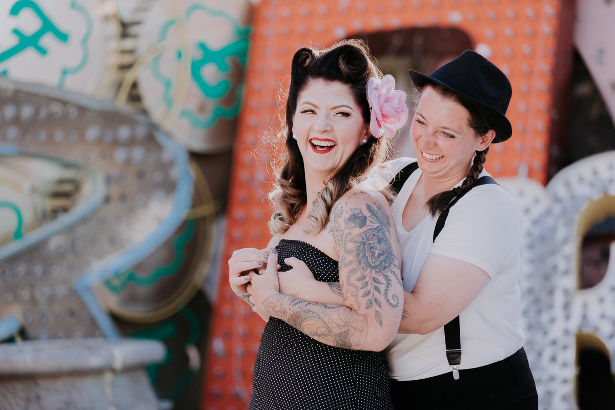 Neon Museum wedding pictures two brides embrace and laugh