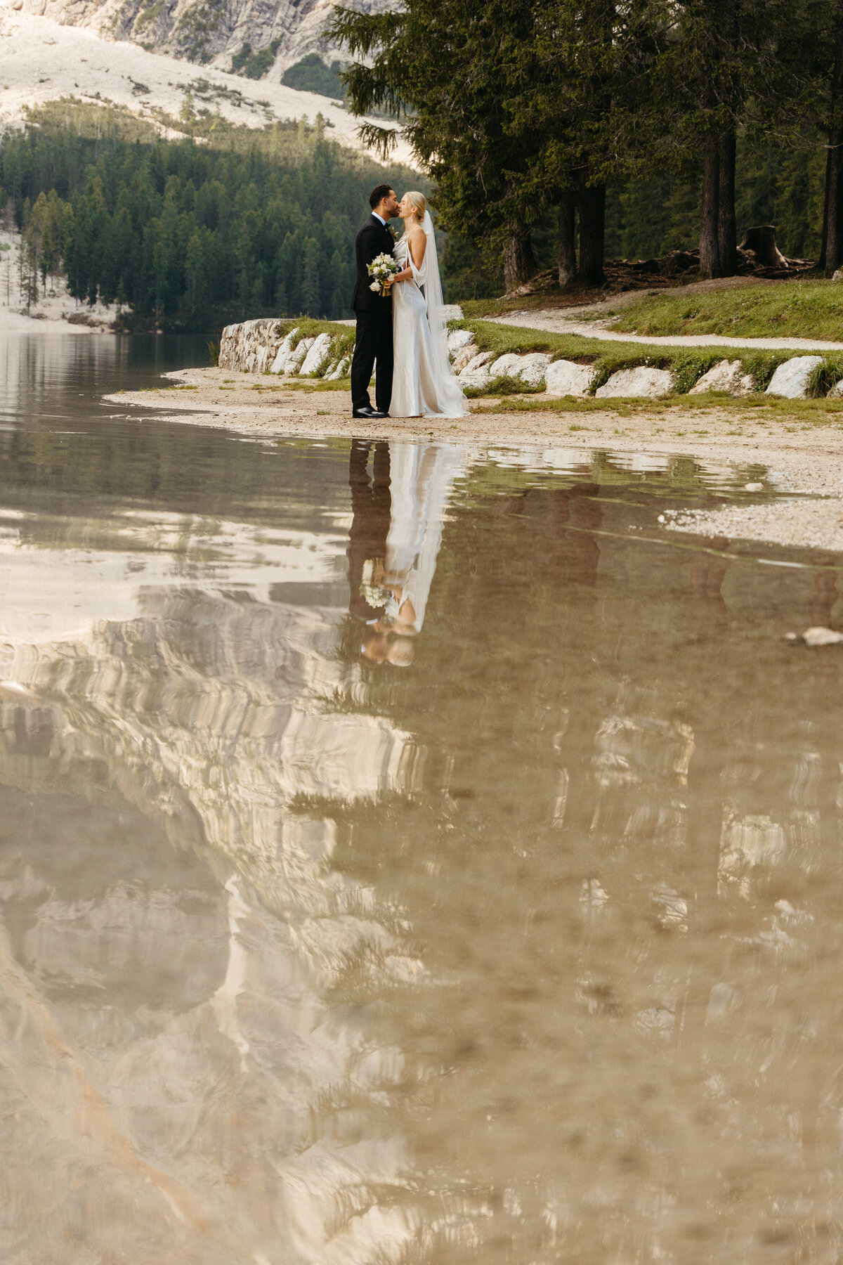 Bride and groom standing at water’s edge during elopement ceremony