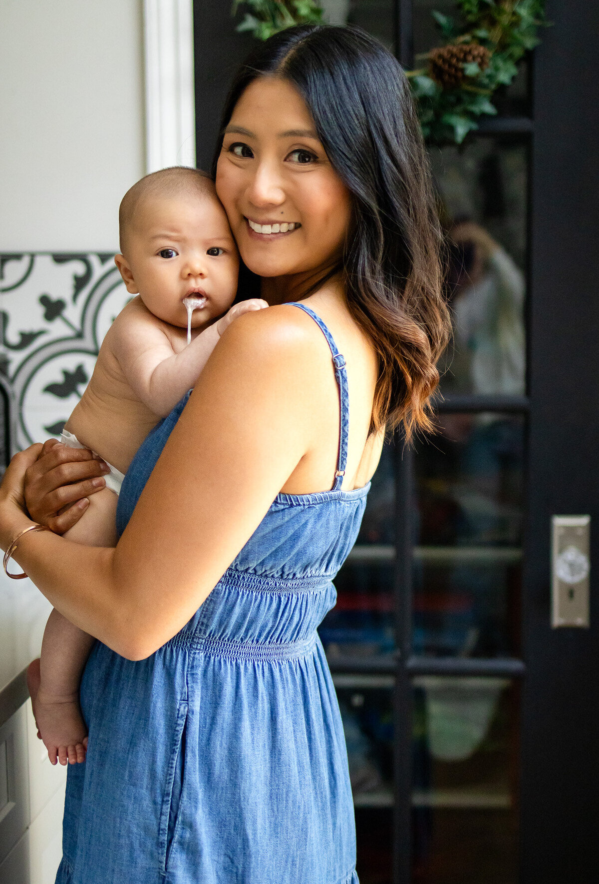 Baby drooling and spitting up on mother’s shoulder in a warm and playful embrace, taken by San Francisco newborn photographer.