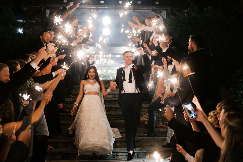  Bride and groom walk hand in hand through a sparkler exit tunnel at Old Edwards Inn during their Highlands, NC wedding.