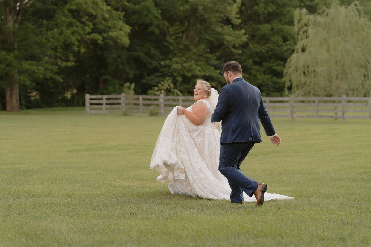 A photo of a bride and groom running through a field playfully at Hidden Meadows in Afton, TN. 