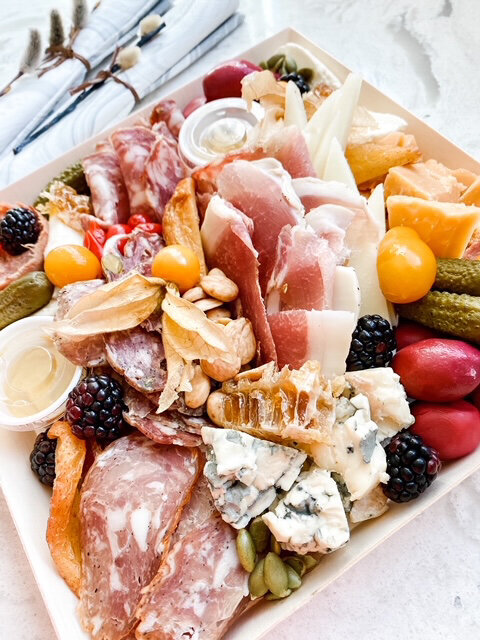 Artisan charcuterie Nosh Box, with cured meat, selection of cheeses, pickles, and berries, created by Food Works Craft Catering, contemporary catering in Calgary, Alberta, featured on the Brontë Bride Vendor Guide.