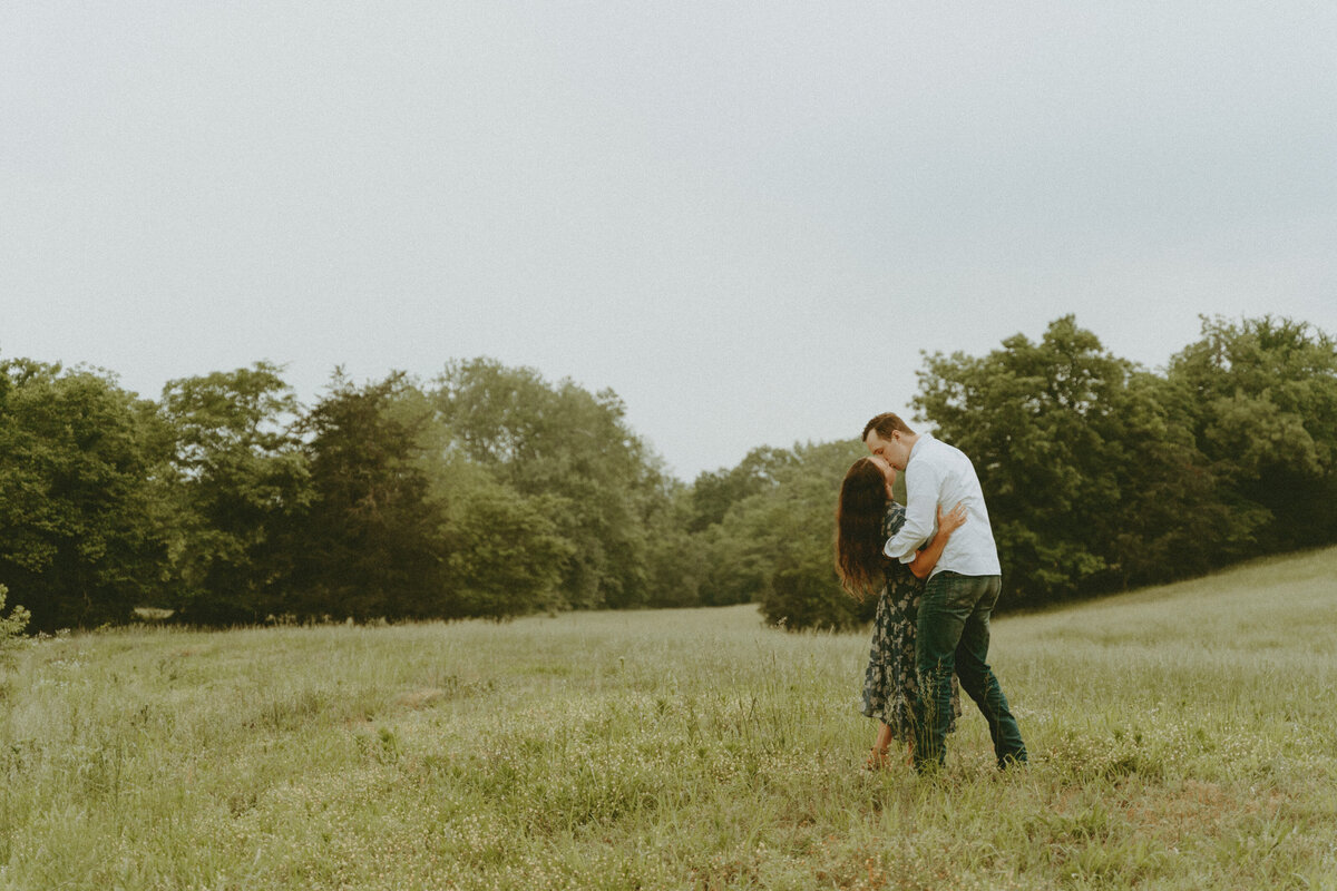 classic dip kiss engagement pose photo in a grassy field