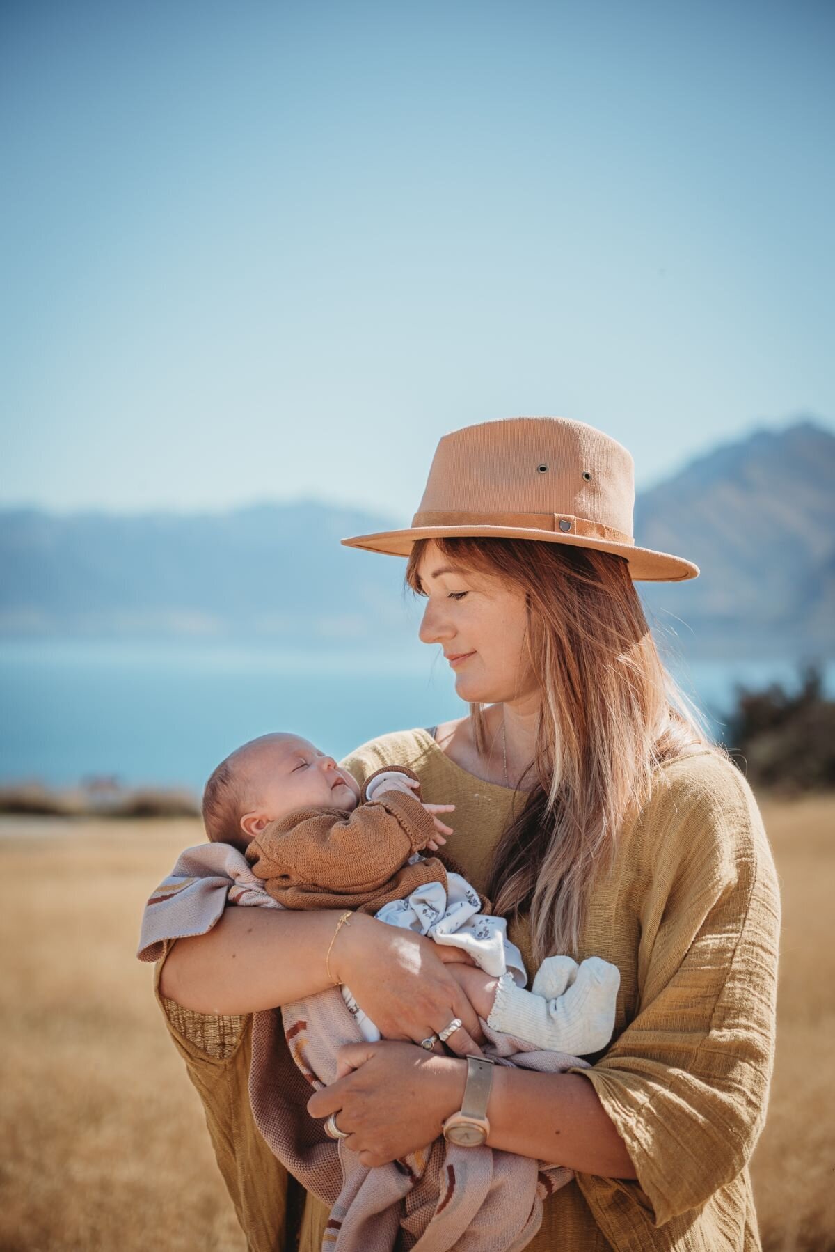 a mum holding her newborn baby  captured by Bie during a newborn photoshoot