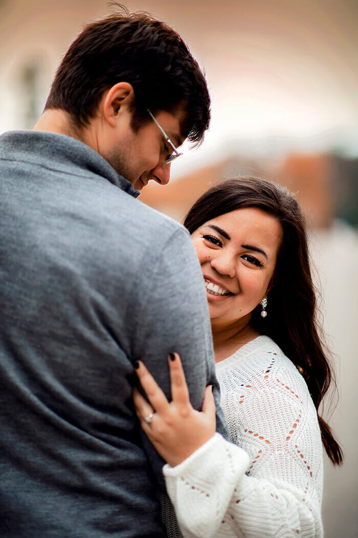 woman-hides-behind-man-looks-at-camera