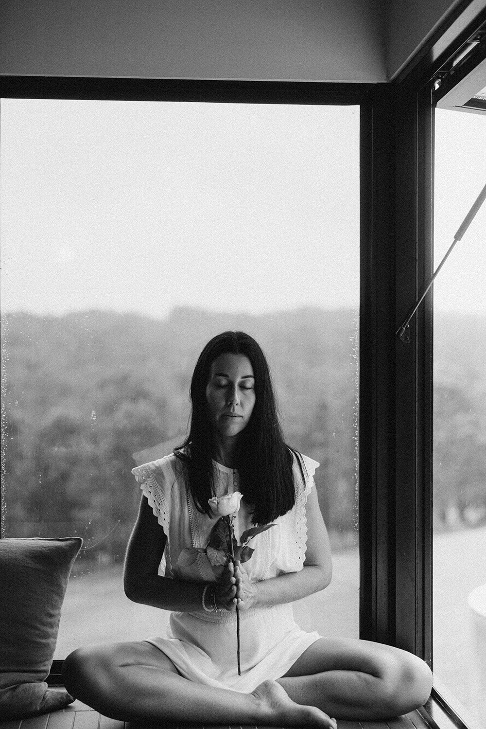 Women in meditation posture holding a rose in a airbnb in the sunshine coast hinterland