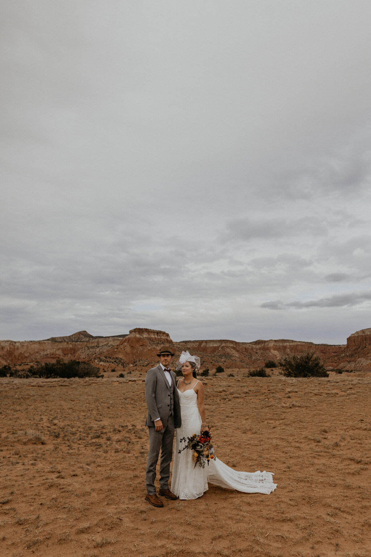 vintage styled bride and groom  standing in the desert