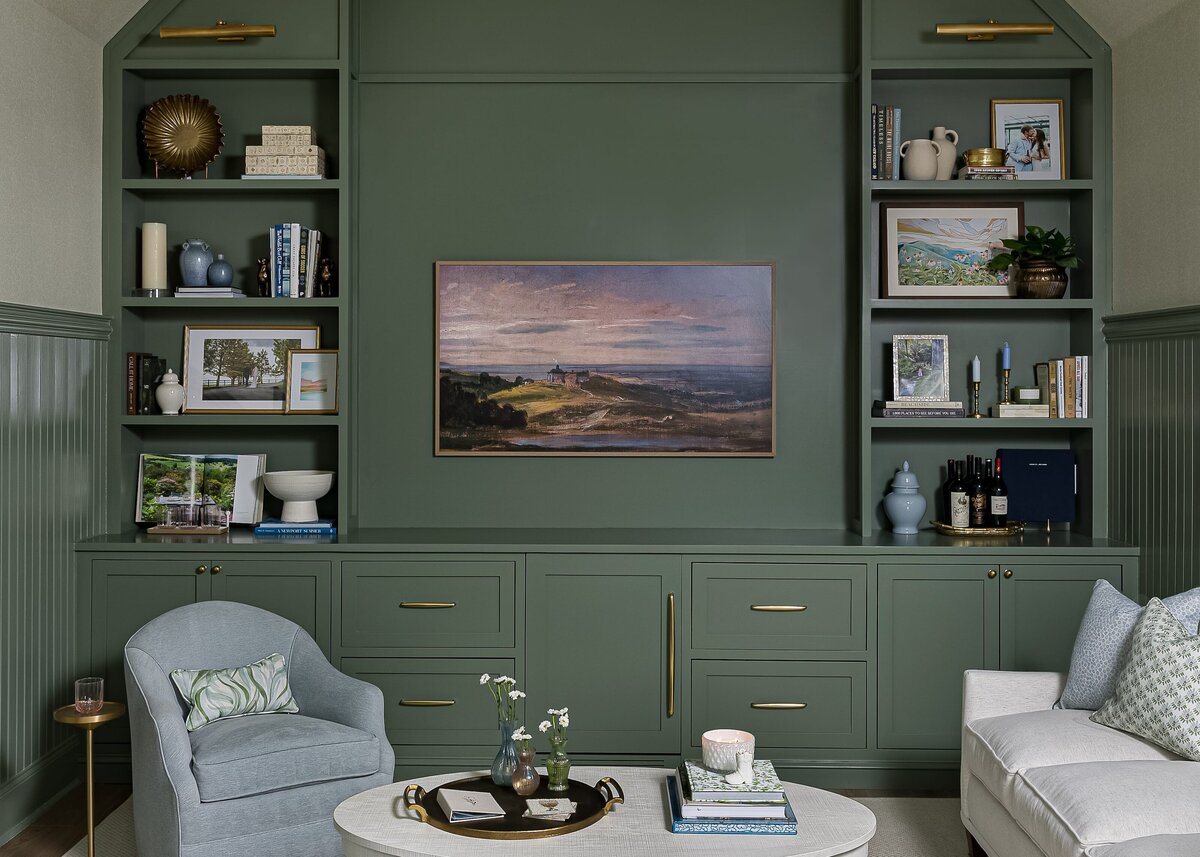 melinda chesson interiors carriage house sitting area with framed tv on wall and green walls