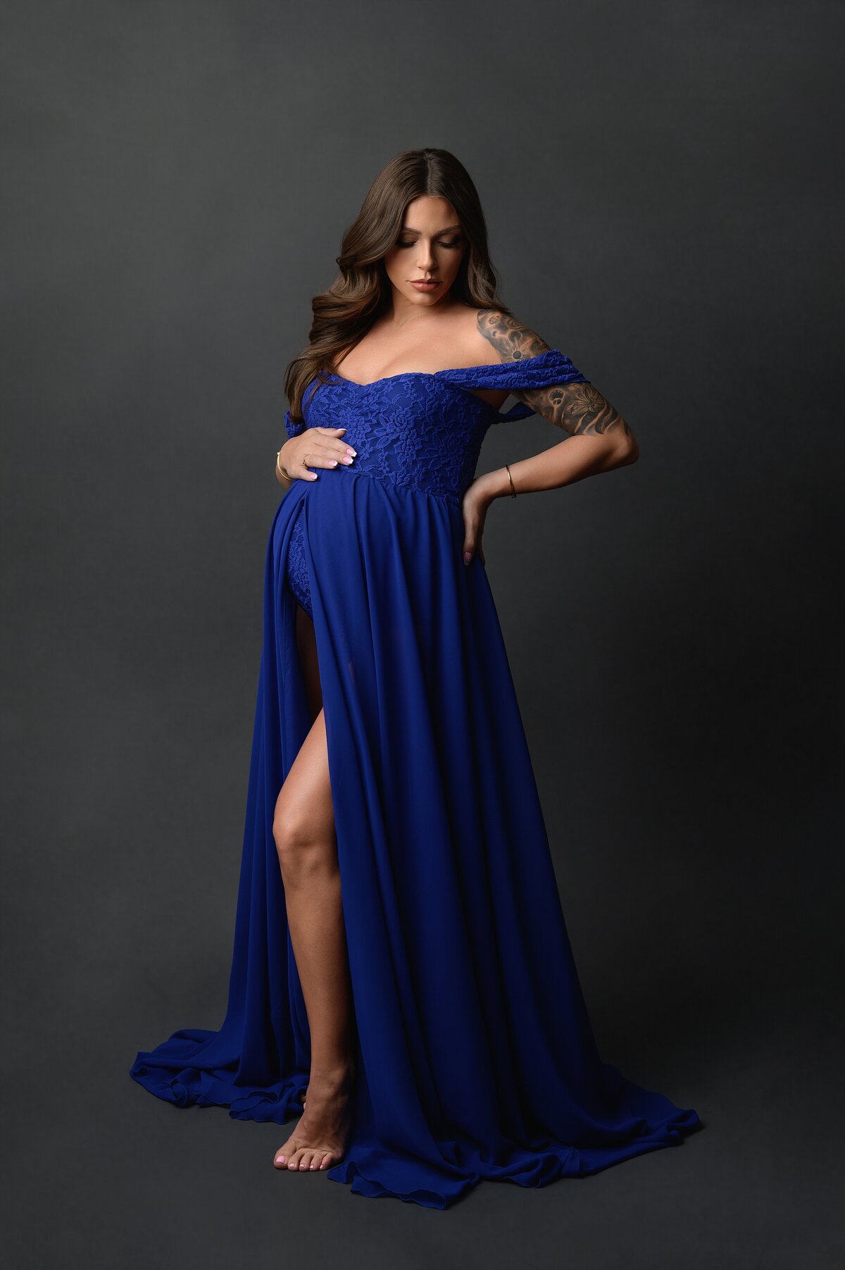 Model wears blue dress for simple studio pregnancy photoshoot