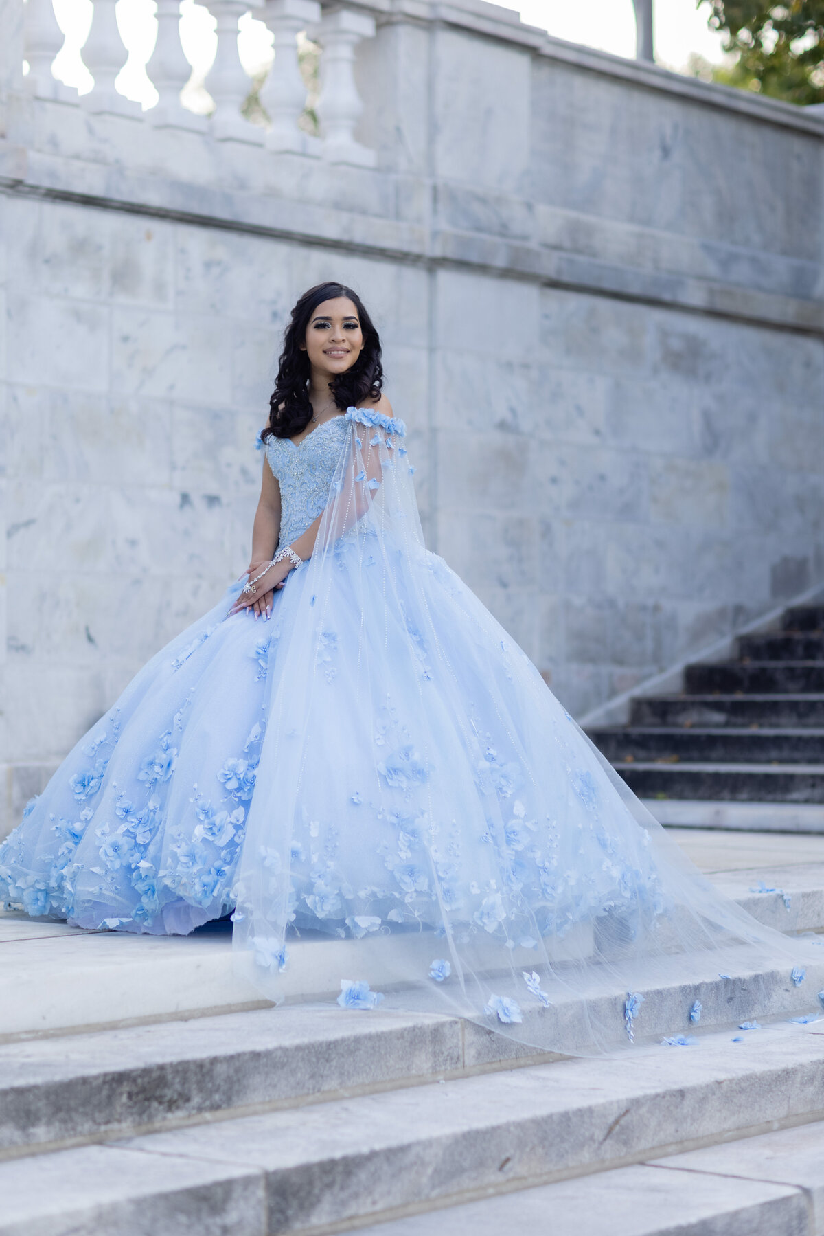 A stunning portrait of Victoria in her blue quinceañera gown on the grand steps at University Circle, Cleveland, Ohio. Capturing timeless elegance with TheWiz Photography.