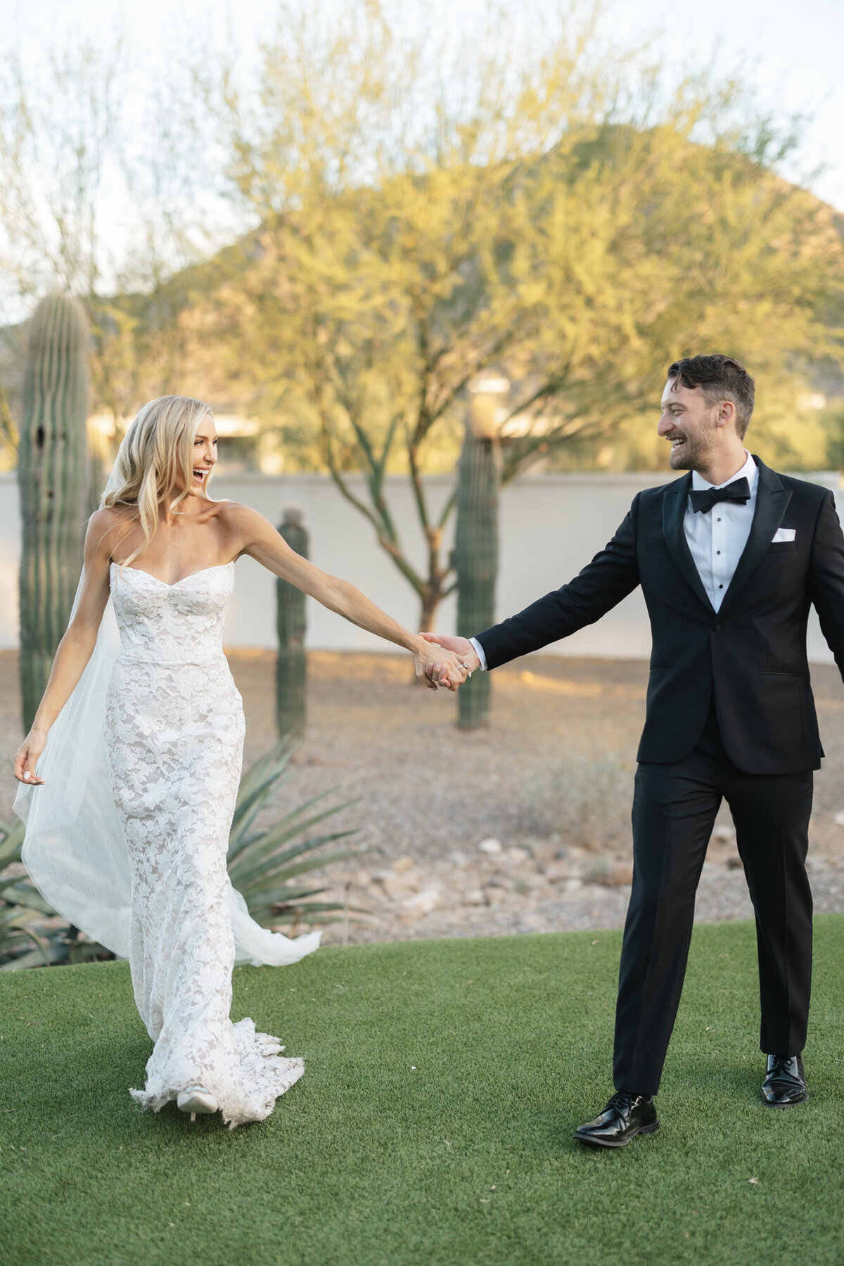 Bride and groom holding hands and smiling at El Chorro in Arizona