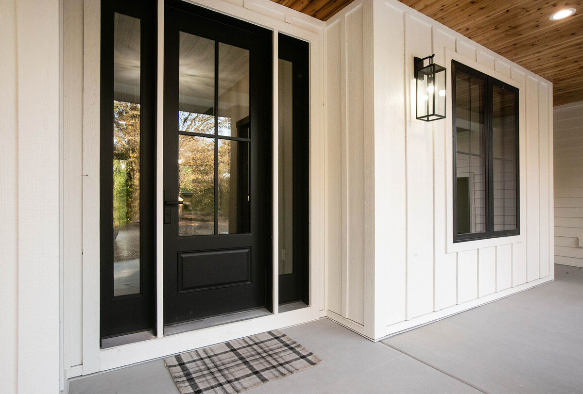 Exterior view of custom home in Big Lake Township, Minnesota with farmhouse details, cream siding, wood pillars and front porch built by Cornerstone Custom Builds