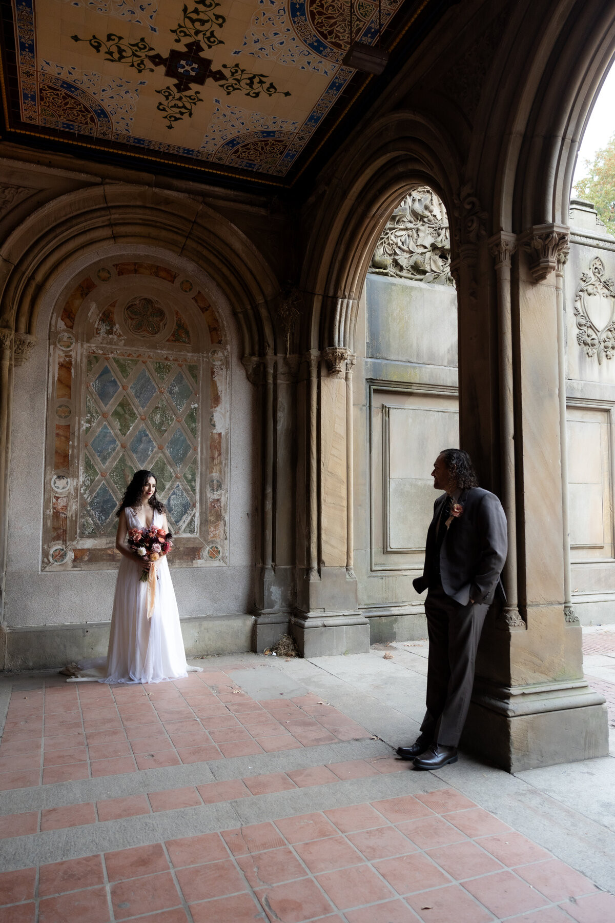 The couple sharing a tender moment beneath Central Park’s beautiful stone arches.