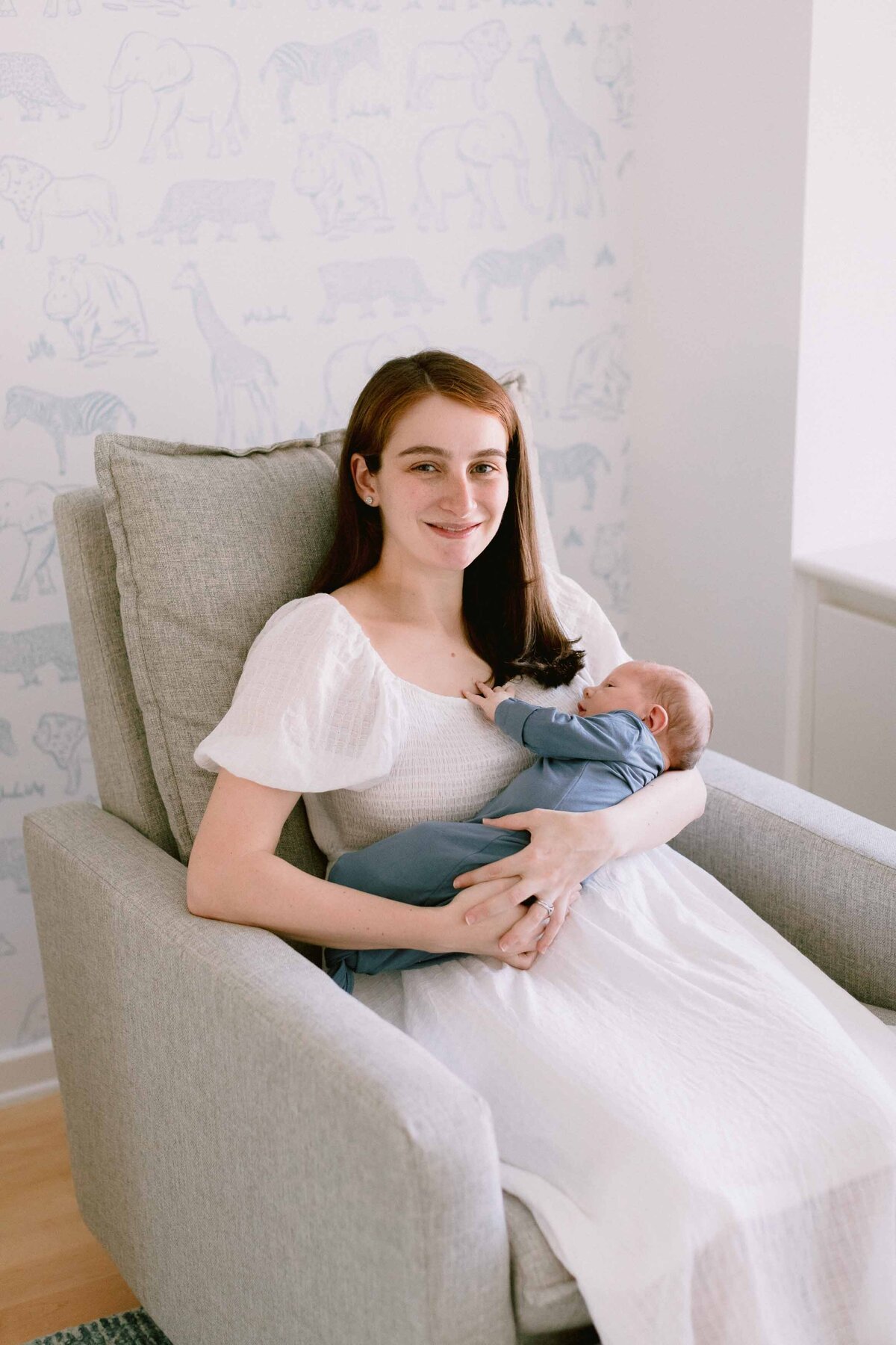 Mom holding her new baby boy and smiling at the camera