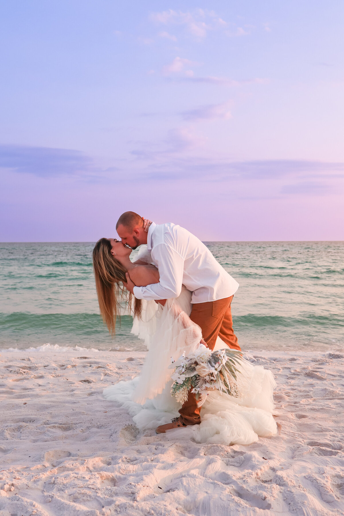 bride and groom dipping and kissing on beach in Panama City Beach Florida by Florida elopement photographer by Amanda Richardson Photography