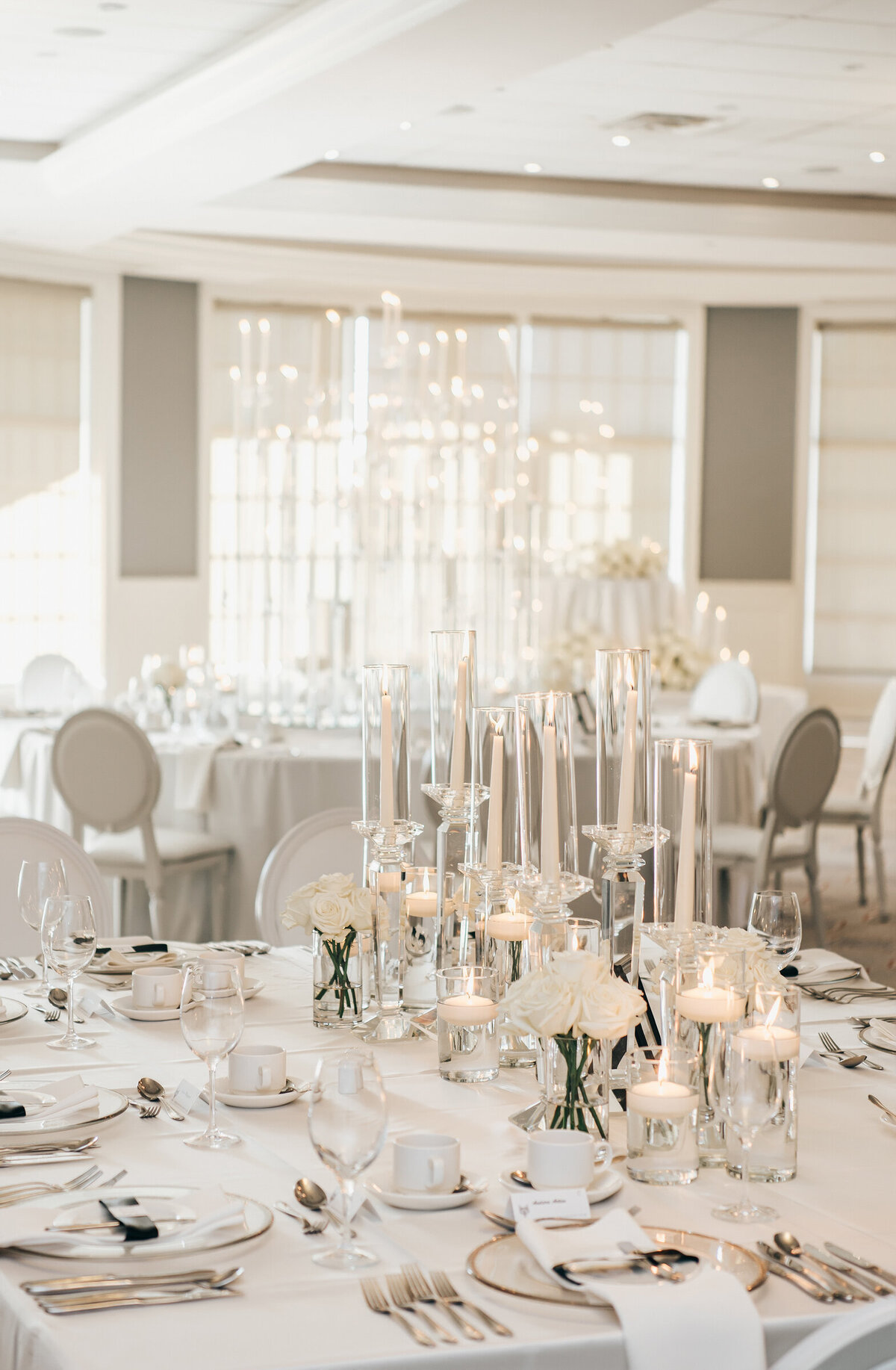 Elegant table settings with white accents and candles at a black tie wedding reception
