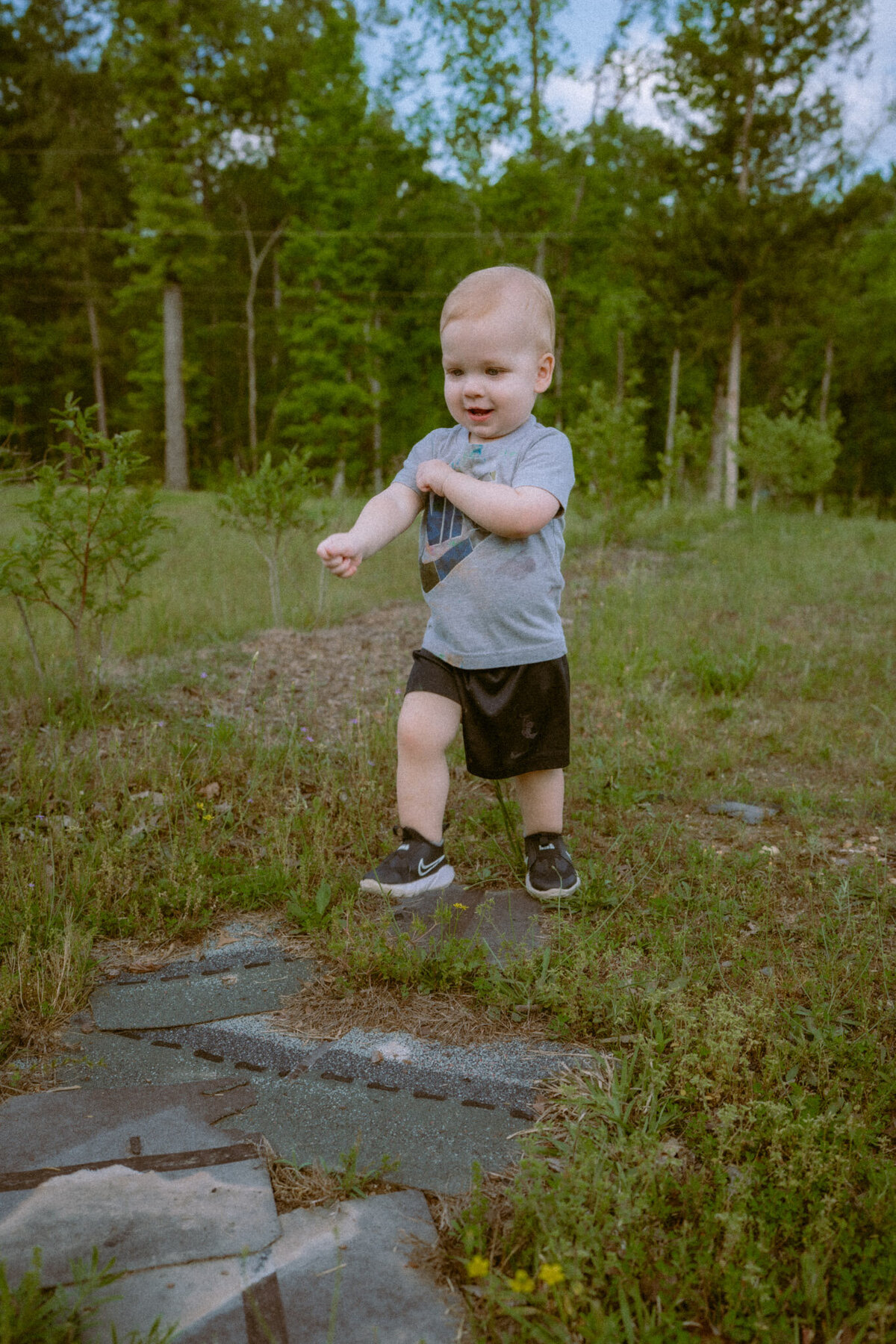Toddler running and playing while moving his arms in an excited manner.