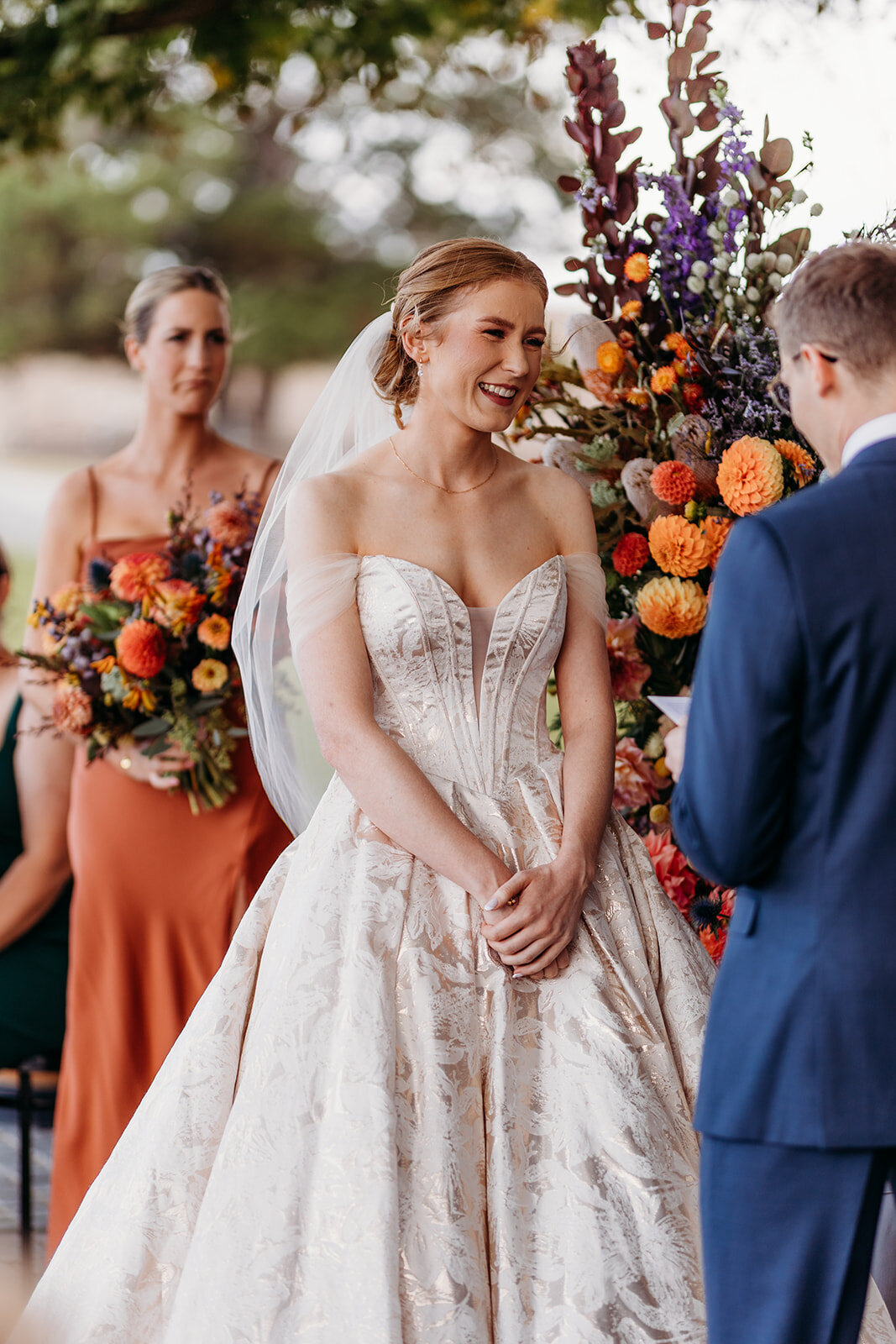 Bride smiles at her husband during their wedding ceremony at Petrichor Farm