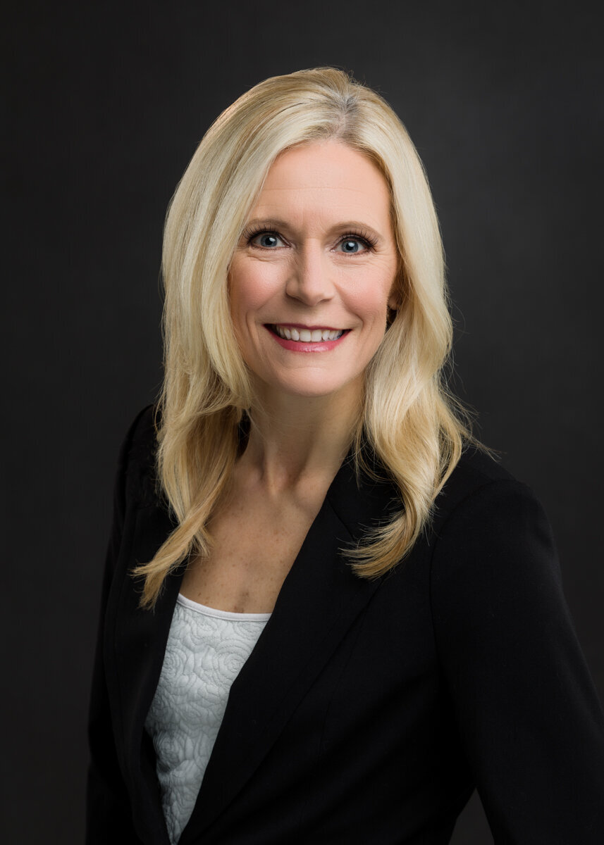 Headshot of a woman wearing a white shirt and black jacket