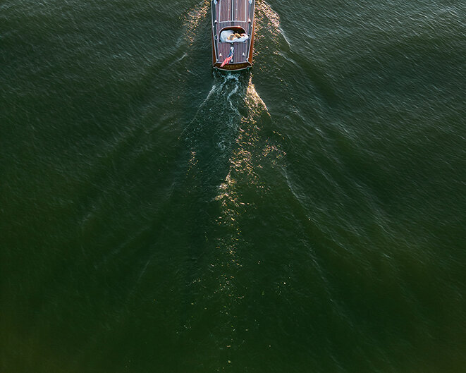 Luxury lake boat portrait with bride & groom by Sarah Bradshaw