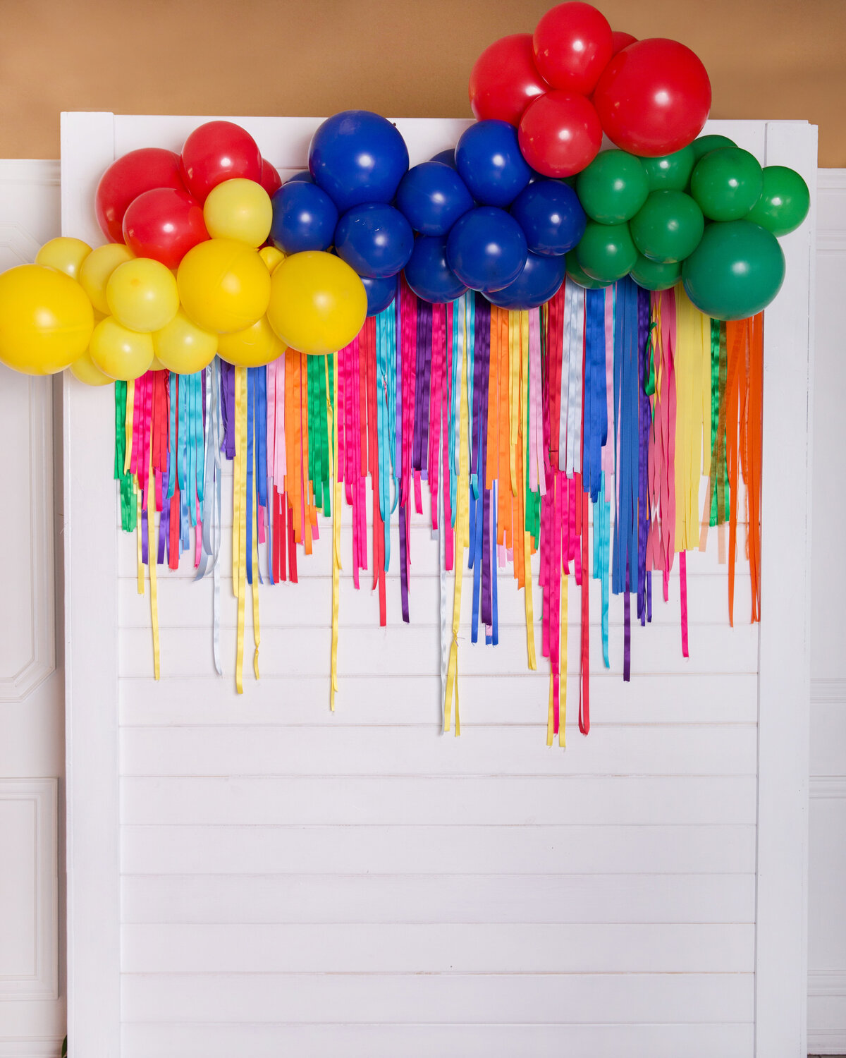Primary colored balloons and streamers on a white backdrop display