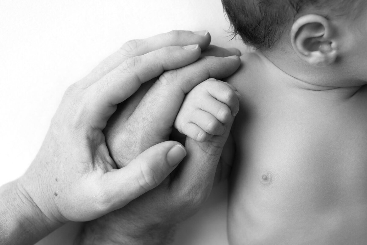 Parent hand holding newborn baby detail Liberty Hill lifestyle photographer