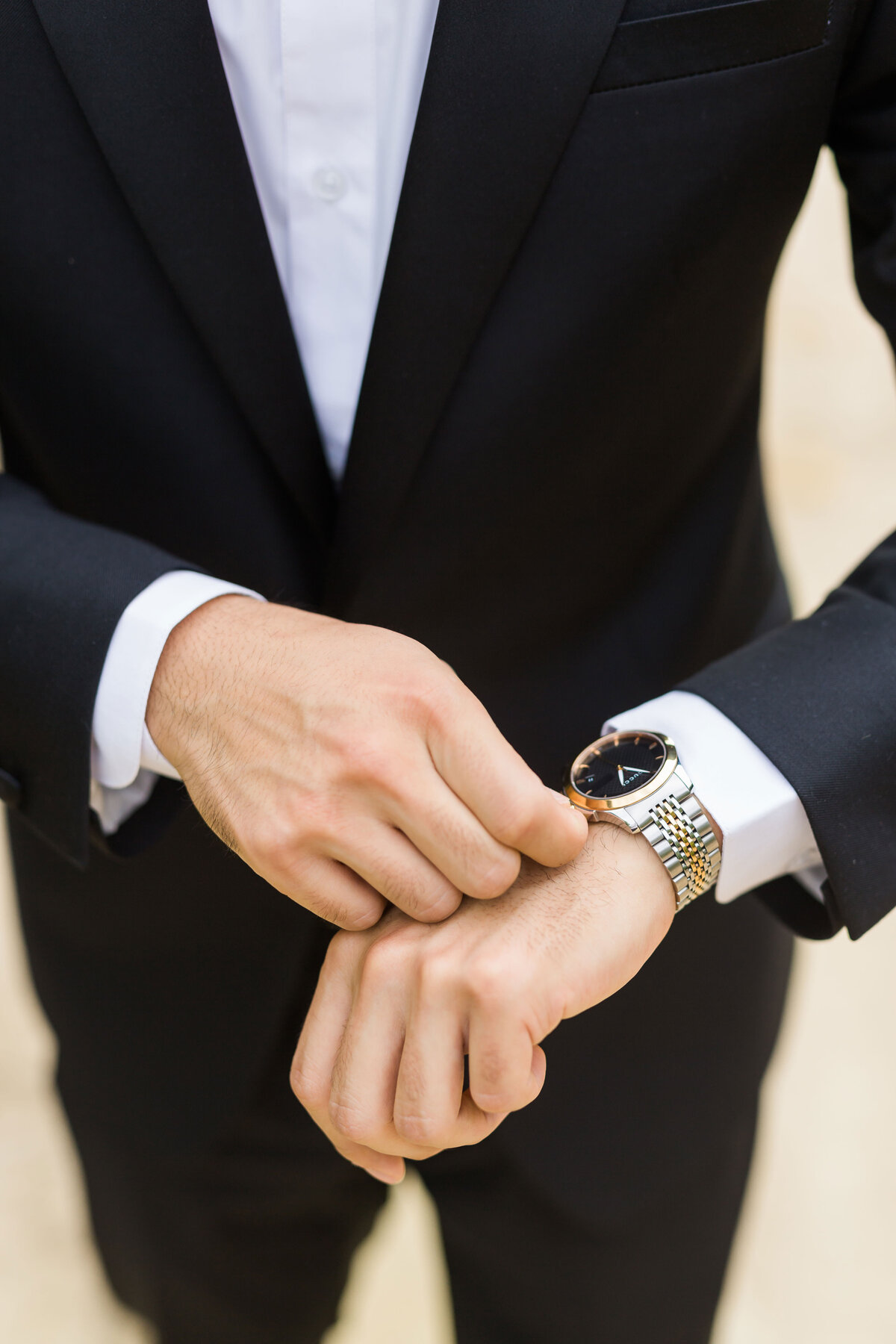 Close up of groom's watch and cuffs on his wedding day