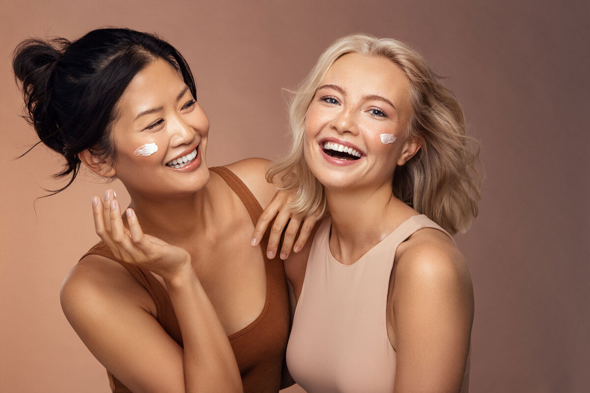 Playful beauty portrait of Danielle Yu and Paulina, smiling with radiant skin, captured by Ylva Erevall.