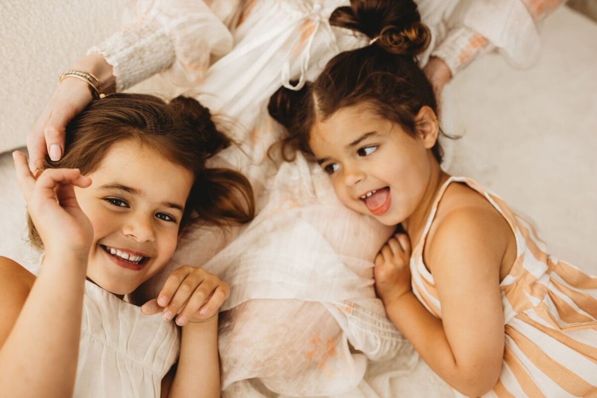 two girls laying down laughing and having a great time next to each other