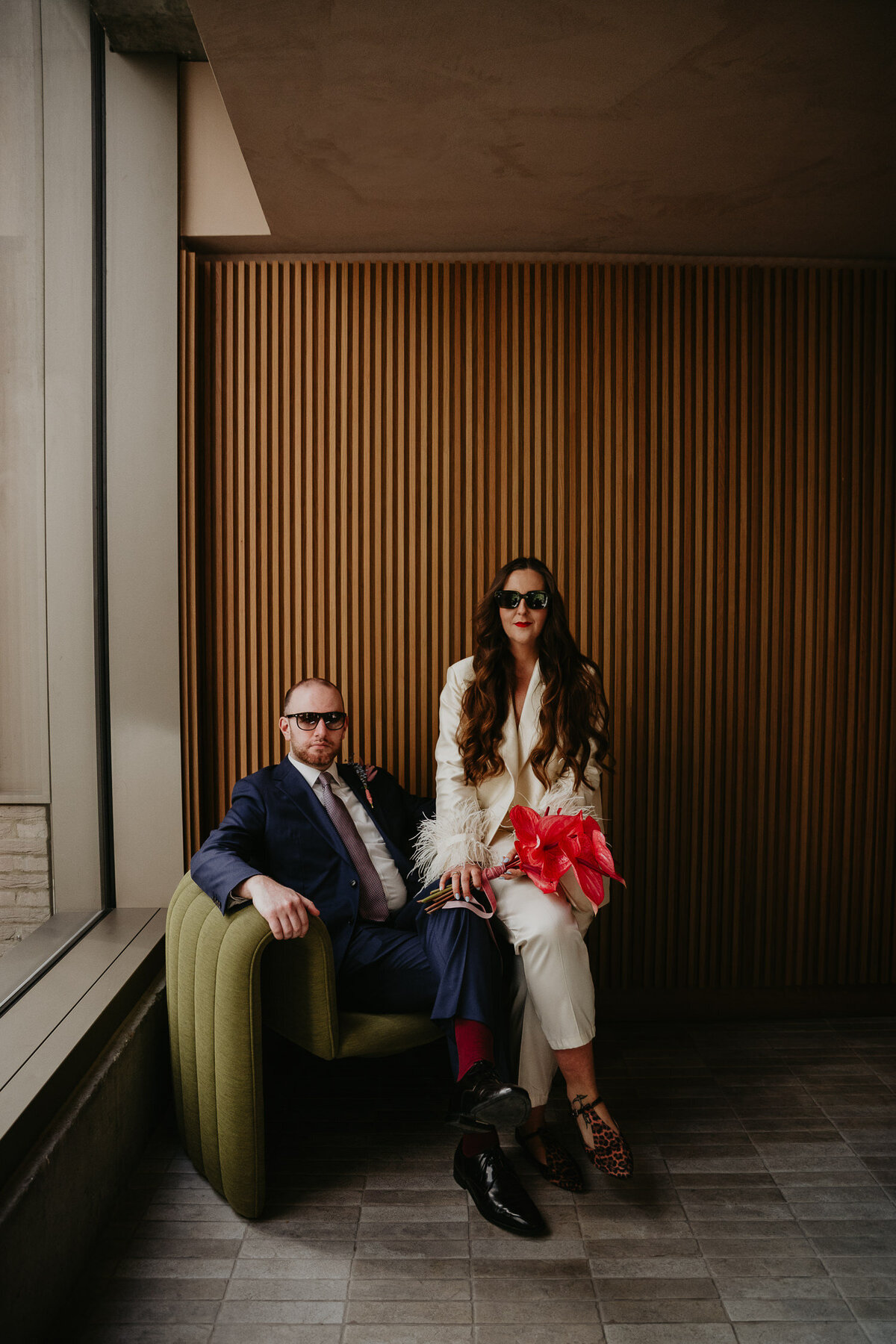 A bride and groom pose for their portrait in a Scandinavian style hotel lobby on their London Micro Wedding. 