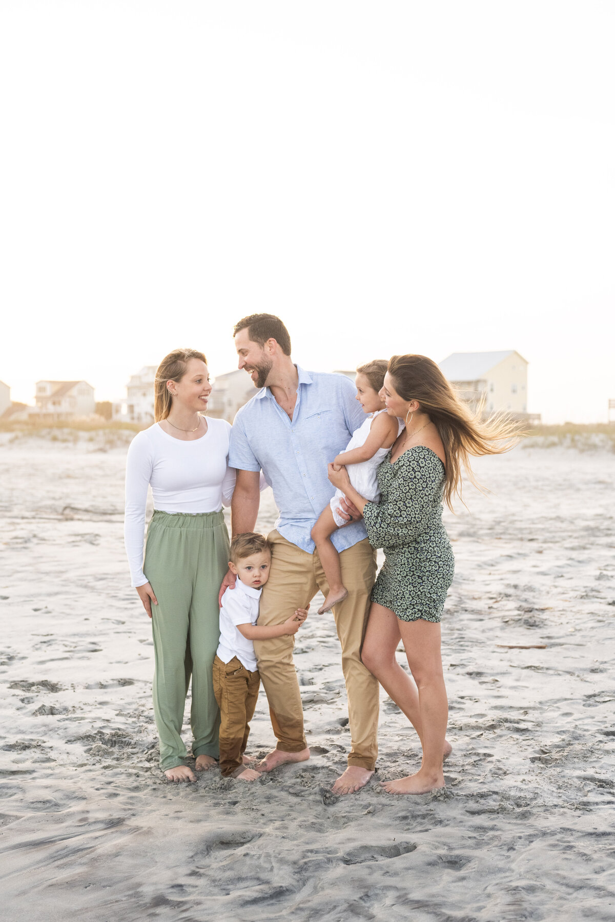 family of 5 standing on the beach during golden hour